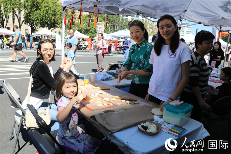 當(dāng)?shù)孛癖婓w驗(yàn)制作中國(guó)美食。 人民網(wǎng)記者 李志偉攝