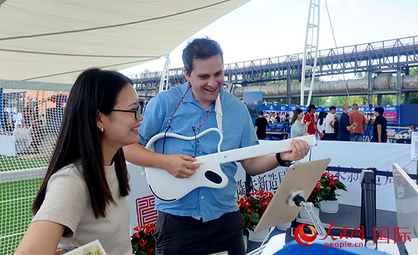 在服貿(mào)會(huì)體育服務(wù)展區(qū)，觀眾體驗(yàn)“陶朱新造局”帶來新材料制作的吉他。人民網(wǎng)記者 吳凱攝