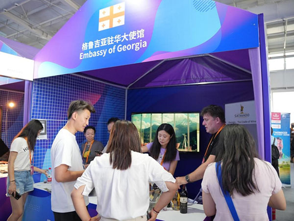 格魯吉亞展臺前，參展商正在向現(xiàn)場觀眾推介相關產(chǎn)品。趙天翊攝