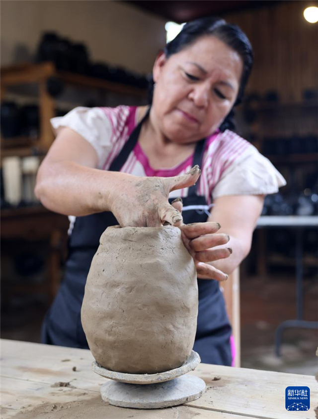 9月14日，在墨西哥瓦哈卡州的圣巴托洛科約特佩克市，一名黑陶手工藝者給陶土塑形。新華社記者 李夢(mèng)馨 攝