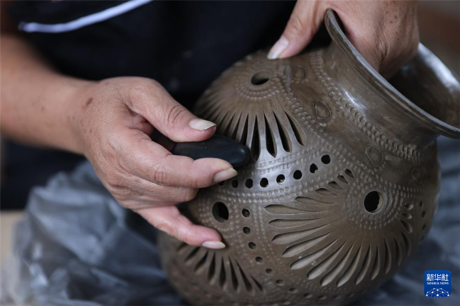 9月14日，在墨西哥瓦哈卡州的圣巴托洛科約特佩克市，一名黑陶手工藝者給陶罐進(jìn)行拋光。新華社記者 李夢(mèng)馨 攝