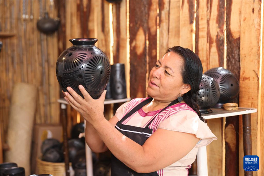 9月14日，在墨西哥瓦哈卡州的圣巴托洛科約特佩克市，黑陶手工藝者檢查自己的作品。新華社記者 李夢馨 攝