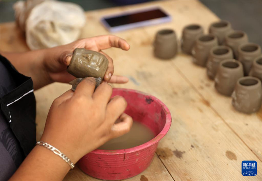 9月14日，在墨西哥瓦哈卡州的圣巴托洛科約特佩克市，一名黑陶手工藝者給陶土塑形。新華社記者 李夢馨 攝