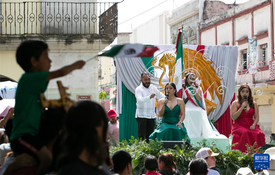 9月16日，在墨西哥瓦哈卡州的瓦哈卡市中心，人們身著國旗顏色的服裝進(jìn)行獨(dú)立日慶祝表演。新華社記者 李夢(mèng)馨 攝