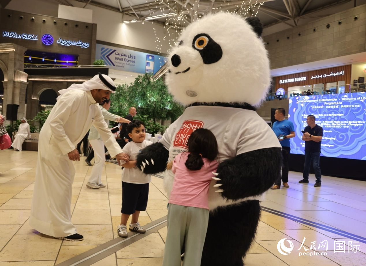 活動現(xiàn)場，當?shù)匦∨笥雅c熊貓玩偶互動。人民網(wǎng)記者 張志文攝