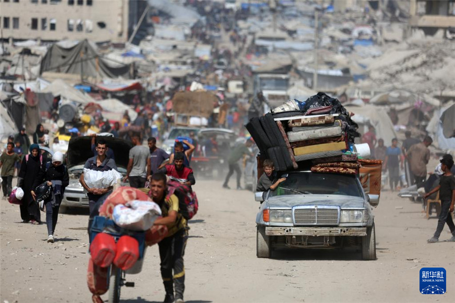 9月18日，在加沙城以西的沿海公路上，人們運(yùn)載著生活用品，匯入人潮向南撤離。新華社發(fā)（里澤克·阿卜杜勒賈瓦德攝）