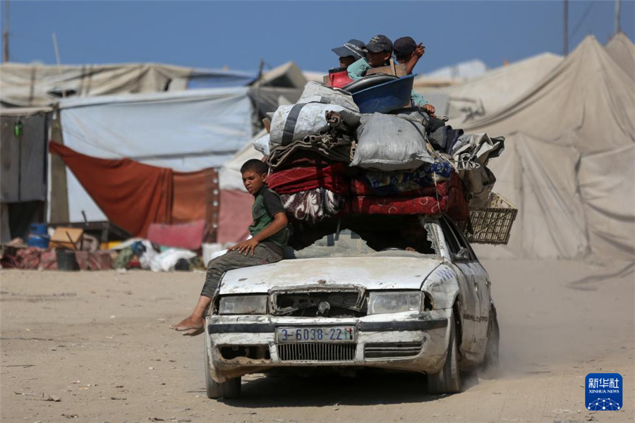 9月18日，在加沙城以西的沿海公路上，兒童與家人一起運(yùn)載著生活用品，匯入人潮向南撤離。新華社發(fā)（里澤克·阿卜杜勒賈瓦德攝）