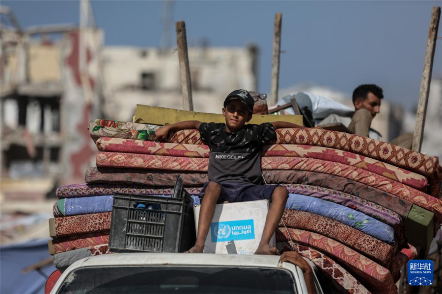 9月18日，在加沙城以西的沿海公路上，兒童與家人一起運(yùn)載著生活用品，匯入人潮向南撤離。新華社發(fā)（里澤克·阿卜杜勒賈瓦德攝）