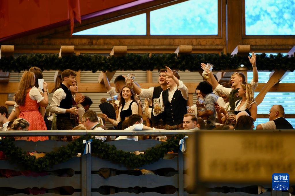 9月20日，人們在德國慕尼黑啤酒節(jié)上享用啤酒。新華社記者 張豪夫 攝