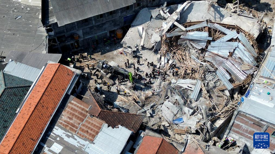 10月4日，救援人員在印度尼西亞東爪哇省詩都阿佐縣的學校建筑物倒塌事故現(xiàn)場搜救（無人機照片）。