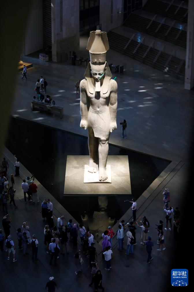 10月14日，在位于埃及吉薩省的大埃及博物館，游客在古埃及法老拉美西斯二世的巨像旁參觀。新華社發(fā)（艾哈邁德·戈馬攝）