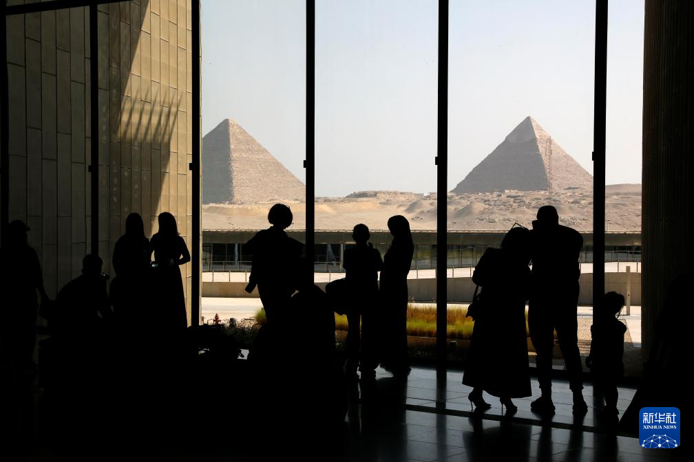 10月14日，游客在位于埃及吉薩省的大埃及博物館遠(yuǎn)觀吉薩金字塔群。新華社發(fā)（艾哈邁德·戈馬攝）