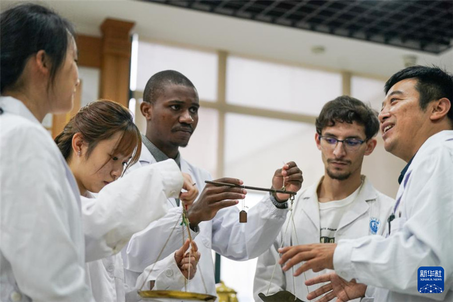 10月16日，安徽中醫(yī)藥大學(xué)老師潘銀星（右一）帶領(lǐng)外國(guó)學(xué)生學(xué)習(xí)秤的使用方法。新華社記者 杜宇 攝