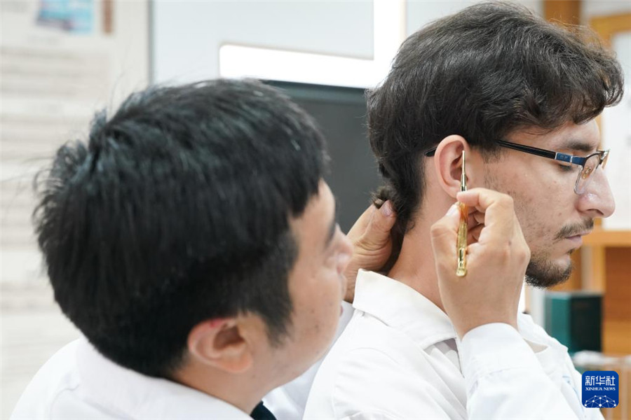 10月16日，安徽中醫(yī)藥大學(xué)老師潘銀星（左）教學(xué)生們認(rèn)識穴位。新華社記者 杜宇 攝