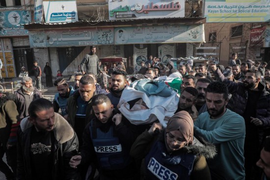 12月16日，人們?cè)诩由车貛е胁砍鞘写鸂柊堇諡橛鲭y記者艾哈邁德·盧送葬。新華社發(fā)（里澤克·阿卜杜勒賈瓦德攝）