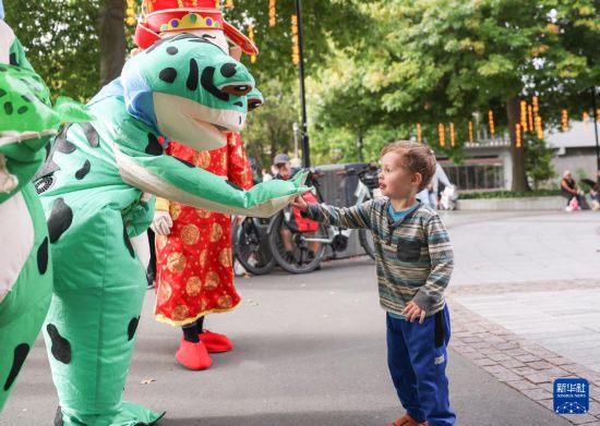 2月7日，小朋友在新西蘭克賴斯特徹奇新春嘉年華活動(dòng)上與青蛙人偶互動(dòng)。新華社記者 龍雷 攝