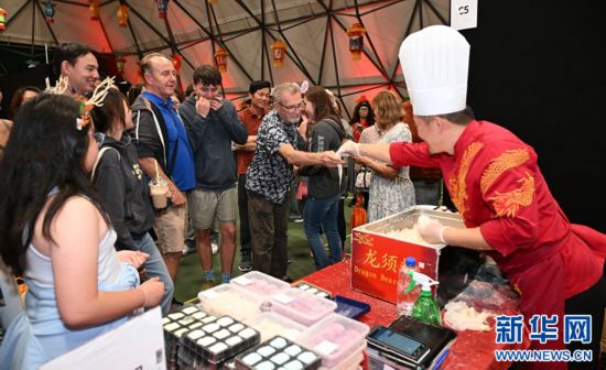 圖為游客在燈節(jié)現(xiàn)場(chǎng)購(gòu)買小吃。（圖片由奧克蘭中國(guó)文化中心提供）