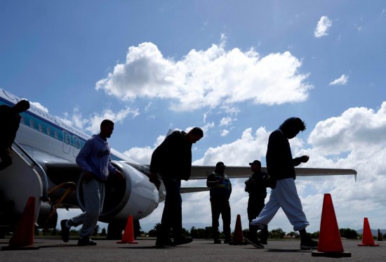 2月14日，在洪都拉斯西北部城市圣佩德羅蘇拉的拉蒙·比列達(dá)·莫拉萊斯機(jī)場(chǎng)，返鄉(xiāng)移民走下飛機(jī)。新華社發(fā)（戴維攝）