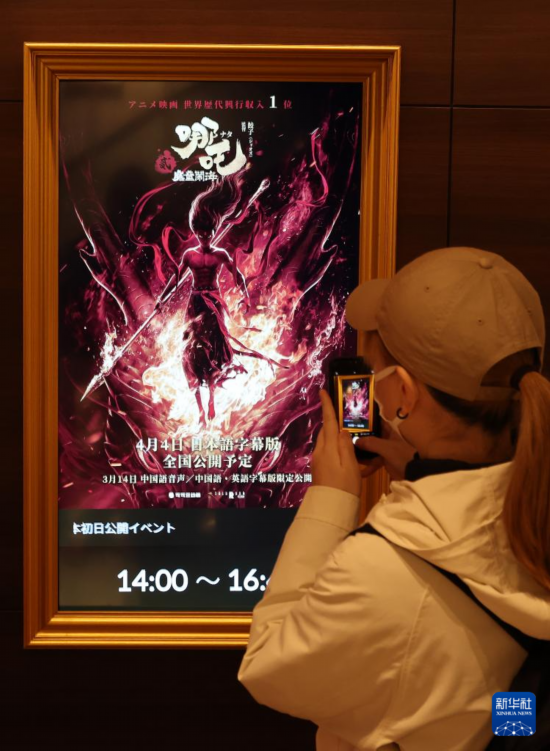 3月14日，在日本東京，一名觀眾拍攝影院中的《哪吒之魔童鬧?！沸麄骱?bào)。新華社記者 賈浩成 攝