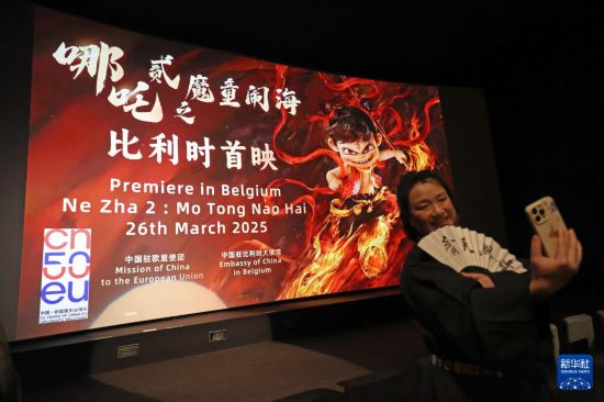 3月26日，在比利時布魯塞爾，觀眾在《哪吒之魔童鬧海》首映活動上拍照。新華社記者 趙丁喆 攝