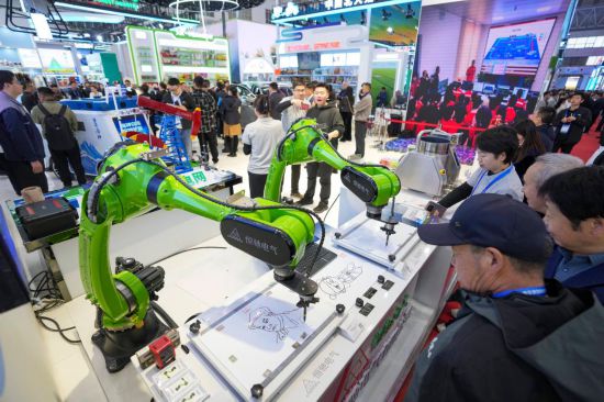 5月17日，在第三十四屆哈洽會(huì)大慶展區(qū)，參會(huì)者在了解一款智能機(jī)械臂的運(yùn)行情況。新華社記者 王建威 攝