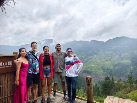 2024年9月，英國(guó)游客湯姆·皮科克-納齊爾（右二）和同行游客在貴州省黔東南苗族侗族自治州雷山縣參觀游覽（資料照片）。新華社發(fā)