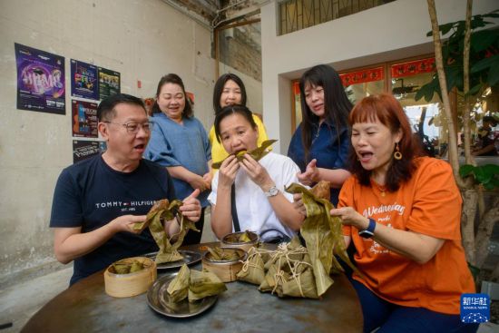 5月31日，在馬來西亞首都吉隆坡，人們在“2025溫馨端午獻溫情”活動上品嘗免費派發(fā)的粽子。新華社發(fā) （張紋綜攝）