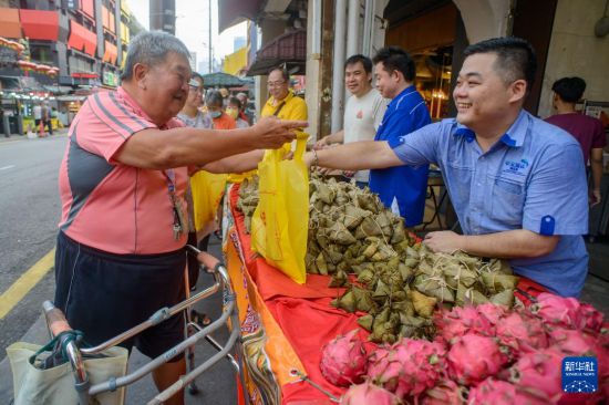 5月31日，在馬來西亞首都吉隆坡，工作人員在“2025溫馨端午獻溫情”活動上為民眾免費派發(fā)粽子。新華社發(fā) （張紋綜攝）