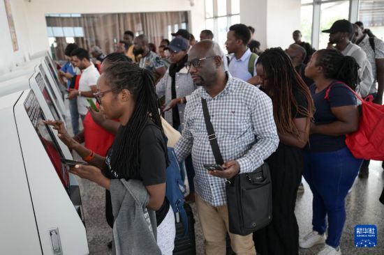 5月31日，在蒙內鐵路內羅畢站，乘客在自助取票機前排隊取票。新華社記者 楊光 攝