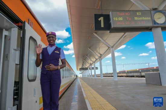 5月31日，在蒙內鐵路內羅畢站，一名乘務員在即將開往蒙巴薩的E2次列車旁等候乘客。新華社記者 楊光 攝
