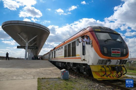 5月31日，在蒙內鐵路內羅畢站，機車駕駛員蔣立平（右）和博爾在即將開往蒙巴薩的E2次列車上揮手致意。新華社記者 楊光 攝