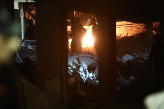 6月15日，在以色列特拉維夫南部巴特亞姆地區(qū)，應(yīng)急人員在導(dǎo)彈襲擊現(xiàn)場(chǎng)開(kāi)展工作。新華社發(fā)（吉德翁·馬科維奇攝/基尼圖片社）