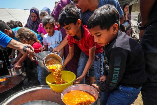 6月3日，巴勒斯坦人在加沙城領(lǐng)取食物。新華社發(fā)（馬哈茂德·扎基攝）