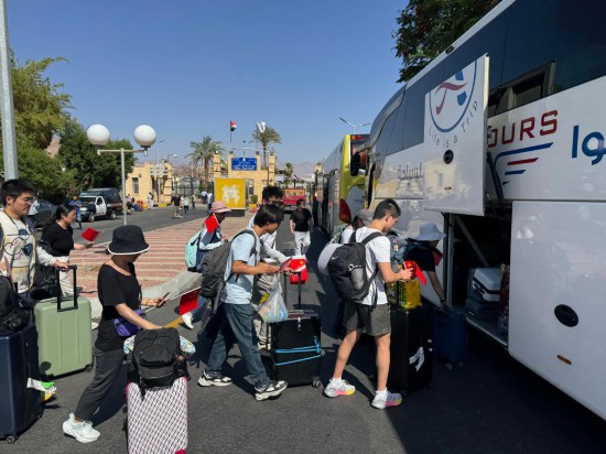 6月19日，在埃及南西奈省塔巴口岸，從以色列撤離的中國公民準(zhǔn)備乘車離開。新華社發(fā)（艾哈邁德·戈馬攝）