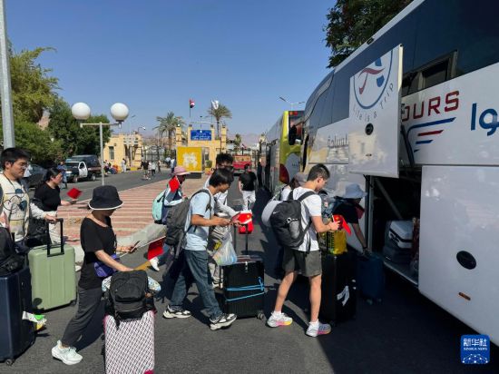 6月19日，在埃及南西奈省塔巴口岸，從以色列撤離的中國公民準(zhǔn)備乘車離開。新華社發(fā)（艾哈邁德·戈馬攝）
