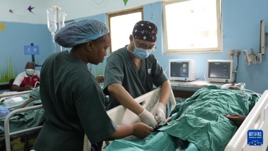 　4月11日，在莫桑比克馬普托，中國援莫醫(yī)療隊醫(yī)生凌勇（右）和當?shù)蒯t(yī)護人員對病人進行術(shù)后護理。新華社記者 劉杰 攝