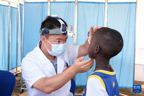 6月27日，在烏干達基庫貝區(qū)的布胡卡三級衛(wèi)生中心，中國醫(yī)療隊隊員為當?shù)鼐用窳x診。新華社發(fā)（阿佳拉·納瓦達攝）