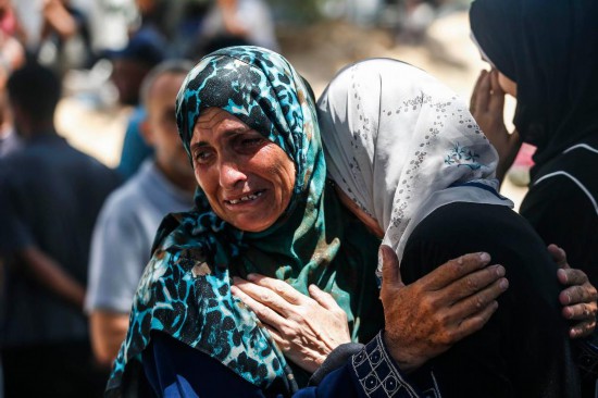 6月25日，巴勒斯坦人在加沙城一所醫(yī)院悼念以軍襲擊中的遇難者。新華社發(fā)（馬哈茂德·扎基攝）