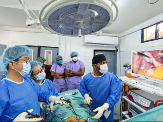 醫(yī)療隊(duì)醫(yī)生錢益（左一）、韓云（左二）與當(dāng)?shù)蒯t(yī)生拉姆哈里（右一）在手術(shù)中（中國醫(yī)療隊(duì)供圖）