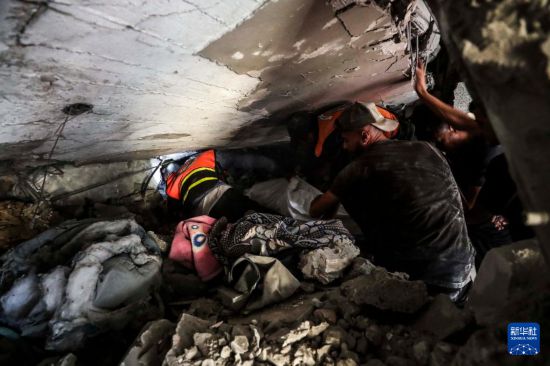 7月6日，巴勒斯坦人在加沙城的建筑廢墟中開展救援工作。新華社發(fā)（馬哈茂德·扎基攝）