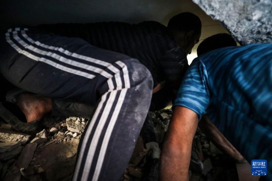 7月6日，巴勒斯坦人在加沙城的建筑廢墟中開展救援工作。新華社發(fā)（馬哈茂德·扎基攝）