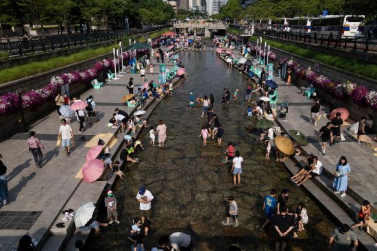 6月14日，人們在韓國首爾的清溪川戲水。新華社發(fā)（全休相攝）