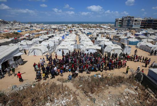 5月28日，人們在加沙城西部的沙提難民營等待領取救助食物。新華社發(fā)（里澤克·阿卜杜勒賈瓦德攝）