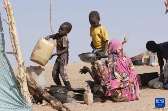 7月9日，婦女和兒童在蘇丹北達爾富爾州法希爾一處流離失所者營地做飯。新華社發(fā)（聯(lián)合國兒童基金會供圖）