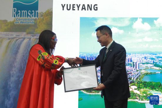 　　7月24日，在津巴布韋維多利亞瀑布城開幕的《濕地公約》第十五屆締約方大會(huì)上，《濕地公約》秘書長(zhǎng)穆松達(dá)·蒙巴為中國湖南岳陽代表頒發(fā)“國際濕地城市”證書。新華社發(fā)（塔法拉攝）