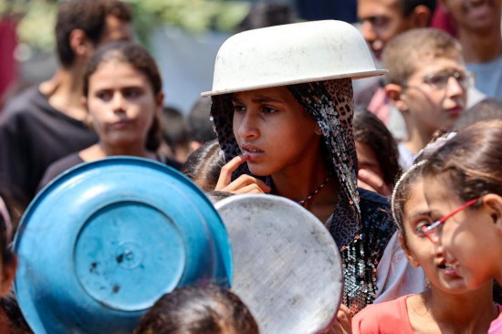 7月25日，人們在加沙城等待領取食物。新華社/法新