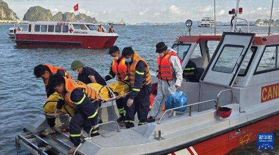 7月26日，在越南廣寧省下龍灣，搜救人員轉(zhuǎn)移遇難者遺體。新華社/越通社