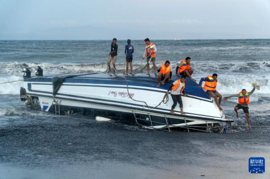 8月5日，在印度尼西亞巴厘島，工作人員將傾覆快艇拉到岸邊。新華社發(fā)（比辛拉西攝）