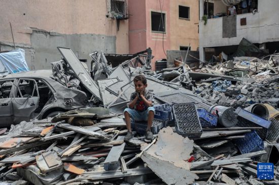  8月8日，一名男孩坐在加沙城以軍襲擊后的廢墟上。新華社發(fā)（里澤克·阿卜杜勒賈瓦德攝）