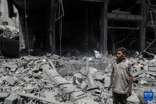 8月8日，一名男孩在加沙城查看以軍襲擊后的廢墟。 新華社發(fā)（里澤克·阿卜杜勒賈瓦德攝）